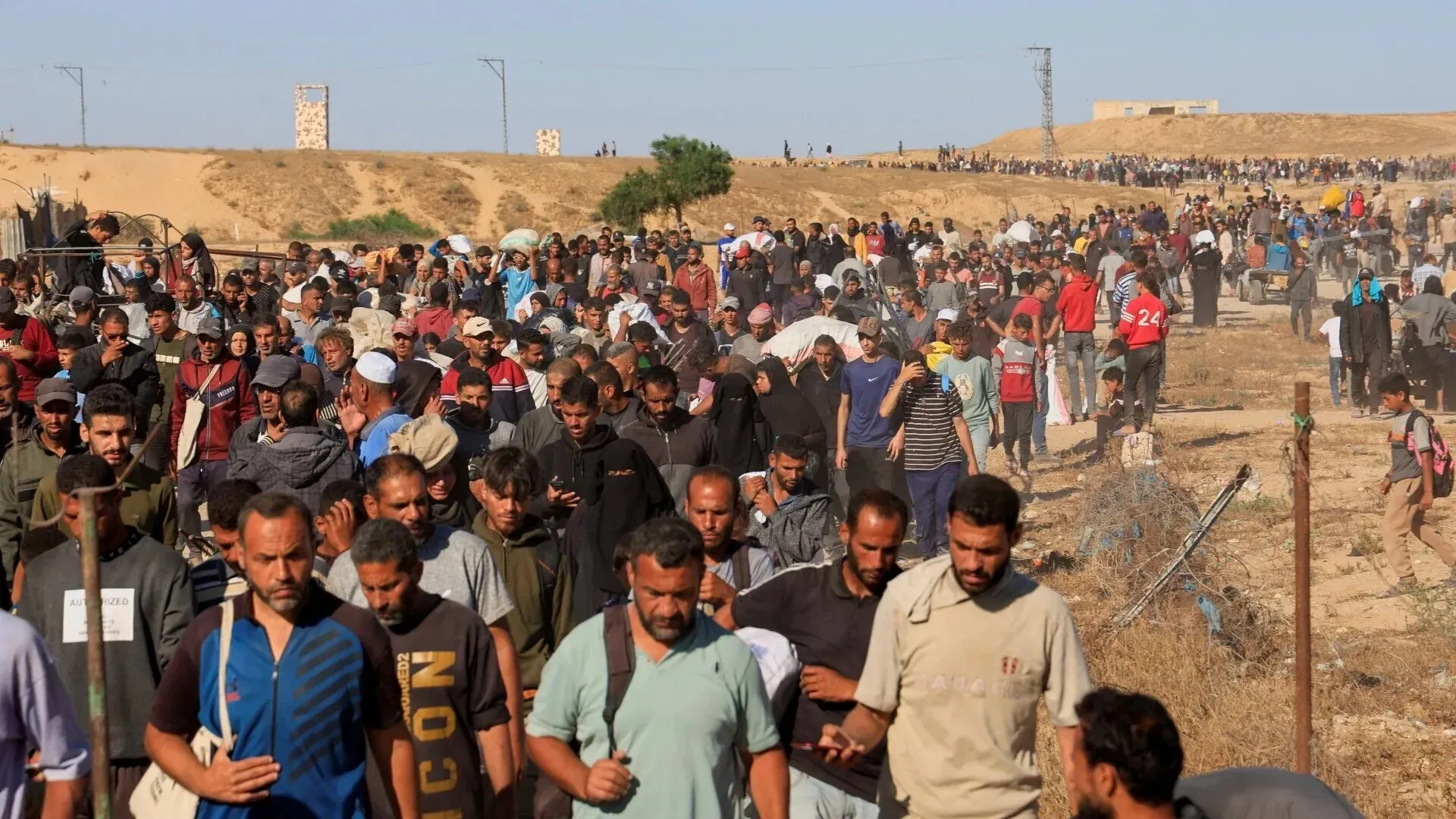 حشود كبيرة من الناس يسيرون في غزة، مع تعبيرات وجهية متنوعة، في ظل ظروف صعبة تعكس الأزمة الإنسانية المستمرة.