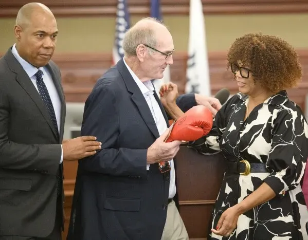 مؤتمر صحفي في Sioux City بحضور العمدة Bob Scott، حيث تم تقديم قفاز ملاكمة تكريماً لجورج Foreman، مع أفراد عائلته.