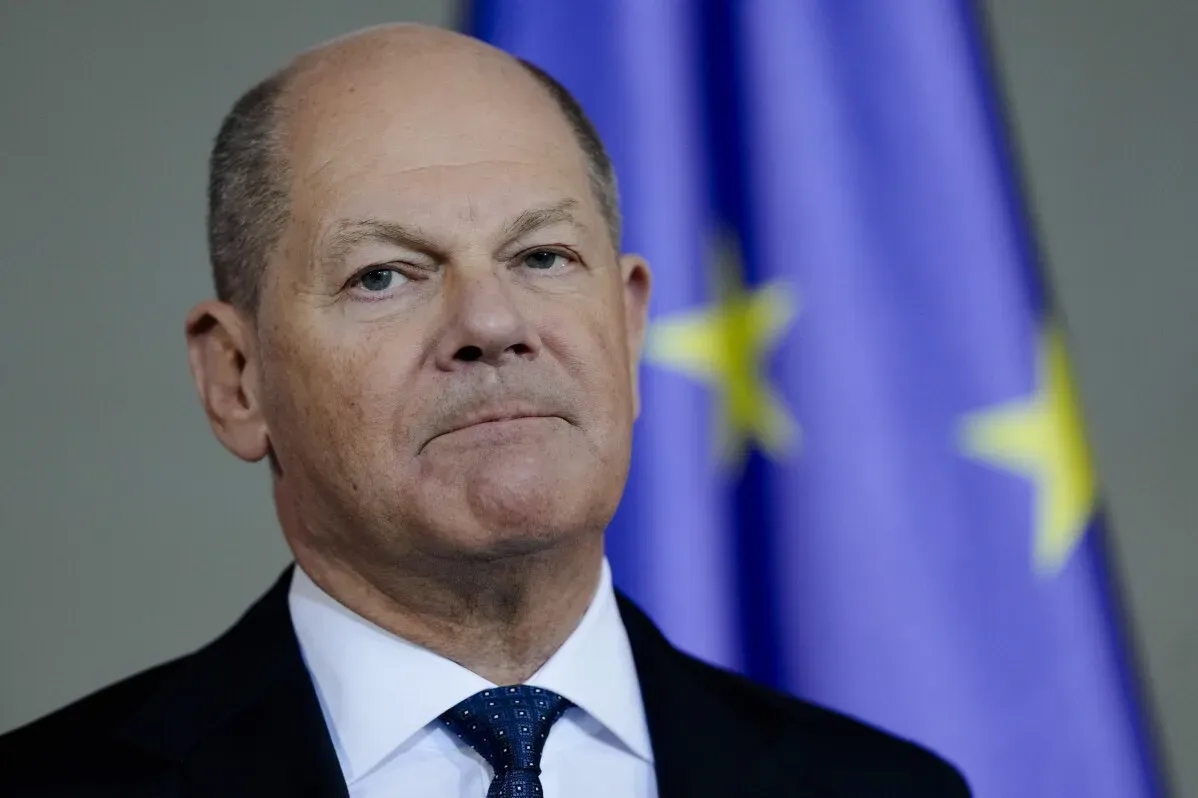 المستشار الألماني أولاف شولتس يتحدث بجدية أمام العلم الأوروبي، معبرًا عن موقفه من حرمة الحدود والتوترات الدولية.