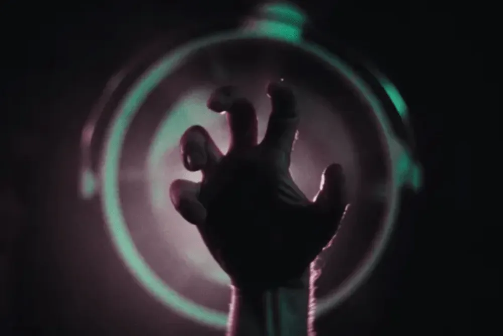 يد بشرية مظلمة ممدودة نحو دائرة مضيئة، تعبير بصري يرمز إلى مشهد من فيلم "The Third Hand" الذي يستخدم الذكاء الاصطناعي لتقليل زمن التصوير.