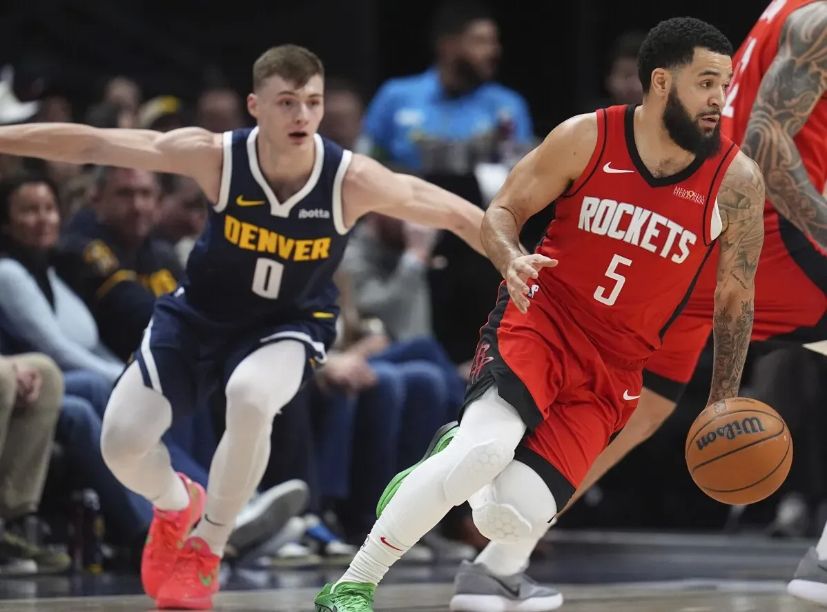 لاعب هيوستن روكتس فريد فانفليت يتقدم بالكرة بينما يلاحقه لاعب دنفر ناجتس، في مباراة كرة سلة حماسية.