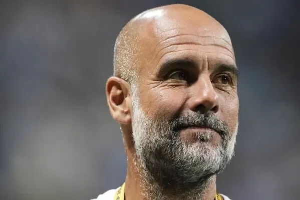 بيب غوارديولا، مدرب مانشستر سيتي، مبتسمًا خلال حفل موسيقي لفرقة Oasis في مانشستر، حيث أهدى ليام غالاغر أغنية له.