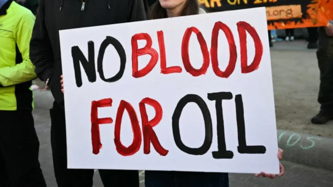 لا للدم من أجل النفط، لافتة تحمل رسالة احتجاج ضد الحروب التي تثيرها المصالح النفطية.