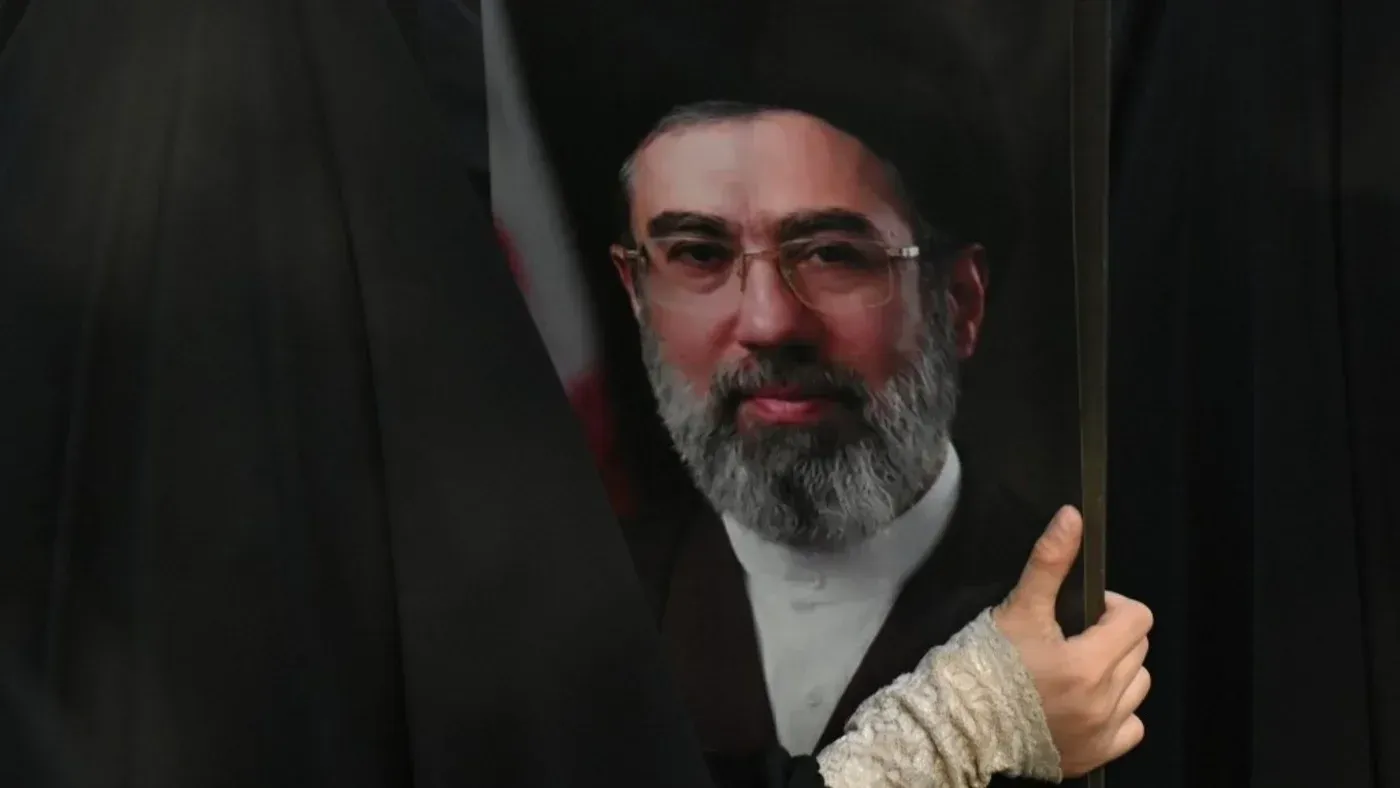 صورة لشخص يحمل صورة للمرشد الأعلى الجديد لإيران، آية الله السيد مجتبى الحسيني خامنئي، خلال حدث دعماً للقضية الفلسطينية.