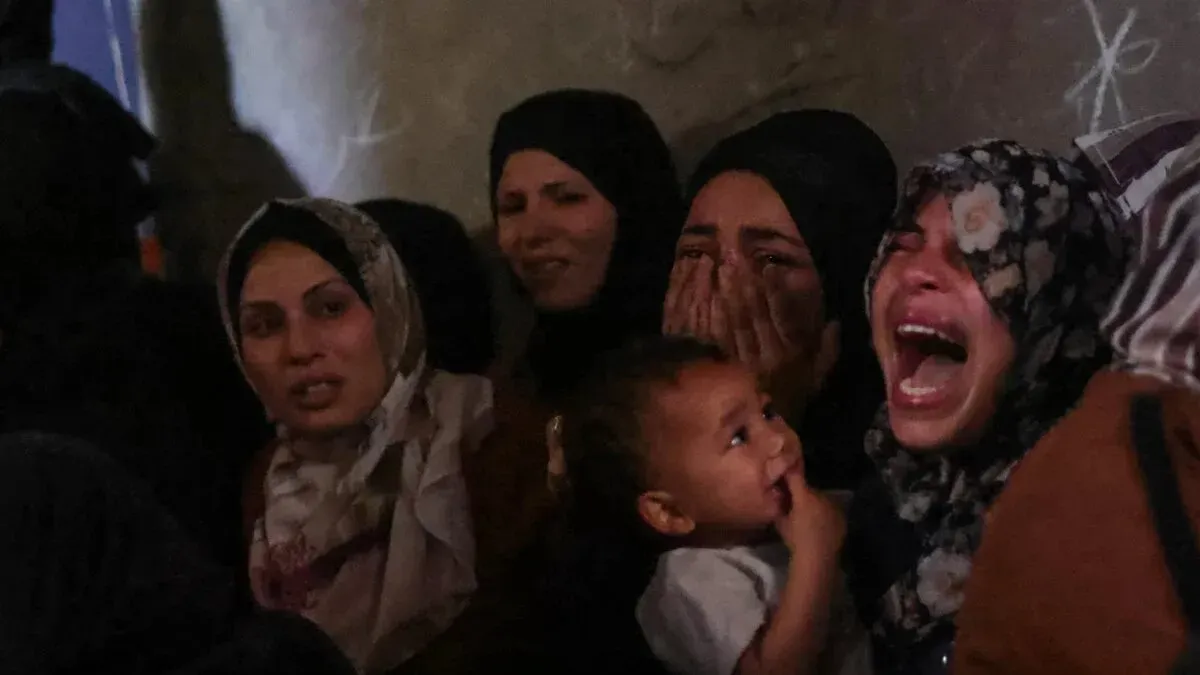 نساء فلسطينيات يعبّرن عن حزنهن وسط الأوضاع الصعبة في غزة، مع وجود طفل في أحضان إحداهن، في ظل استمرار الصراع والمجاعة.