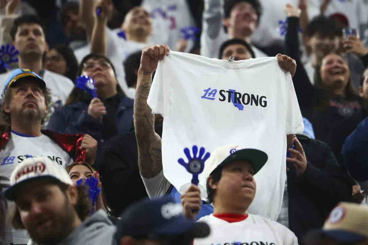 جماهير كليبرز ترتدي قمصاناً بيضاء مكتوب عليها \"LA STRONG\" في تشجيع لفريقهم خلال مباراة ضد ميامي هيت.