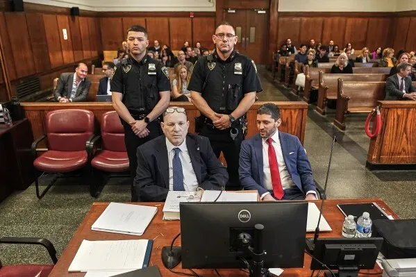 محاكمة هارفي واينستين في نيويورك، حيث يظهر محاموه وموظفو الأمن في قاعة المحكمة، مع التركيز على التوترات القانونية المحيطة بالقضية.