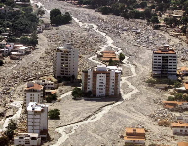 مباني متضررة وسط أنقاض وطمي نهر جارف في ولاية La Guaira بفنزويلا بعد انهيارات طينية وزلزال مدمر.