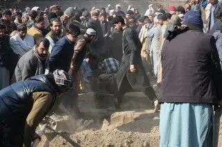 مواطنون أفغان يجتمعون في موقع انهيار منزل في جلال أباد، حيث تم انتشال جثث عائلة ضحايا الأمطار الغزيرة.