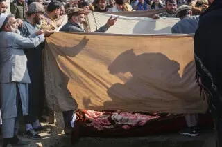 محتجون يحملون قماشًا يغطي جثث ضحايا انهيار منزل في أفغانستان، نتيجة الأمطار الغزيرة، مما يعكس تأثير الكوارث الطبيعية على السكان.