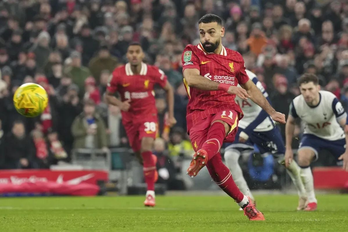محمد صلاح يسدد كرة نحو المرمى خلال مباراة ليفربول، مع زملائه في الفريق في الخلف، في أجواء تنافسية حماسية.