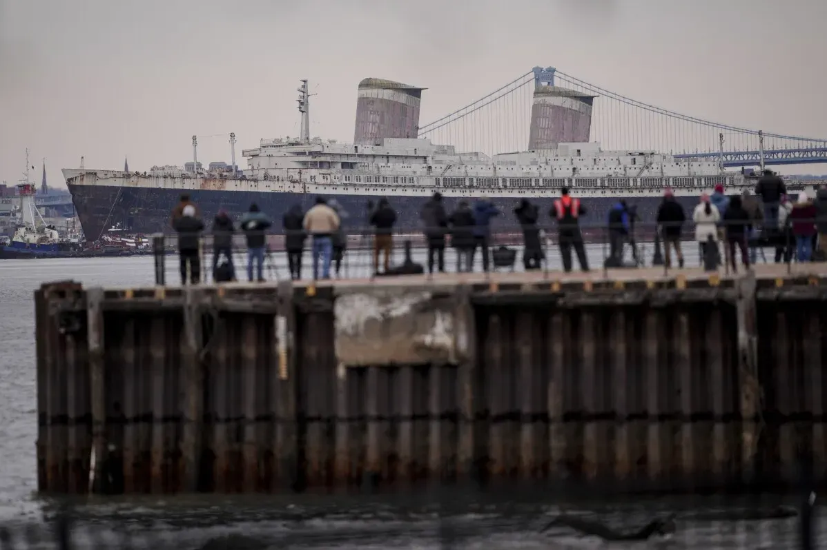 سفينة SS United States التاريخية تبحر من الواجهة البحرية لنهر ديلاوير، بينما يتجمع الناس لمشاهدتها قبل تحويلها إلى شعاب مرجانية اصطناعية في فلوريدا.