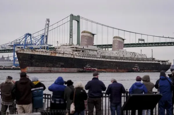 سفينة SS United States التاريخية تُشاهد من قبل مجموعة من الأشخاص بينما تُحضر للإغراق كجزء من مشروع لإنشاء شعاب مرجانية اصطناعية.