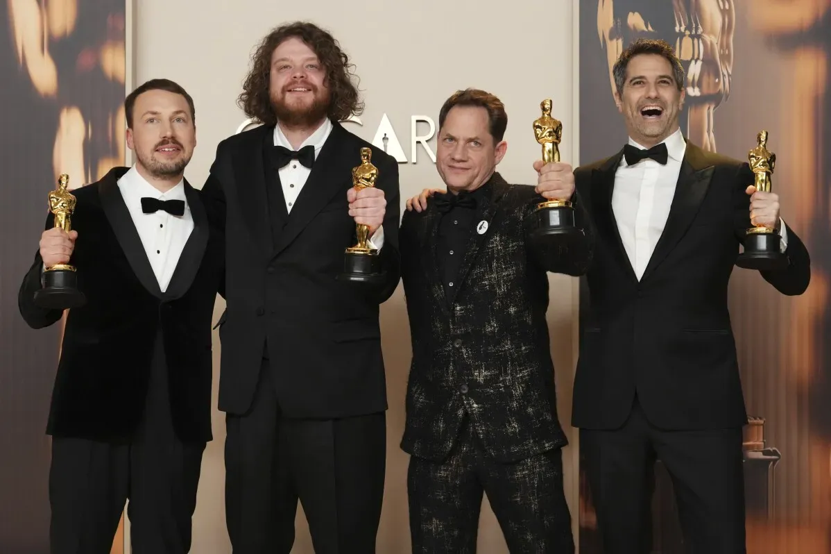 فريق عمل فيلم "فلو" اللاتفي يحتفل بجوائز الأوسكار، حيث يحمل أربعة أعضاء تماثيل الأوسكار في حفل توزيع الجوائز.