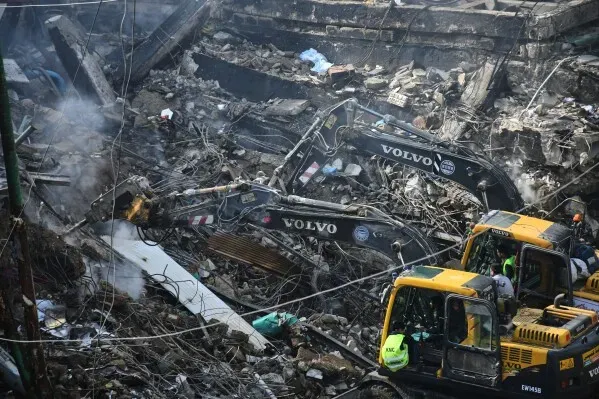 آلات ثقيلة تعمل على إزالة الأنقاض في ساحة غول بلازا بكراتشي بعد حريق هائل، حيث تواصل فرق الإنقاذ البحث عن المفقودين.