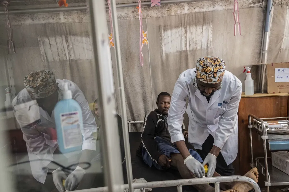 ممرض يعالج مريضًا مصابًا في مستشفى بيثيسدا في غوما، حيث يعاني المستشفى من الاكتظاظ ونقص الإمدادات بسبب النزاع المستمر.
