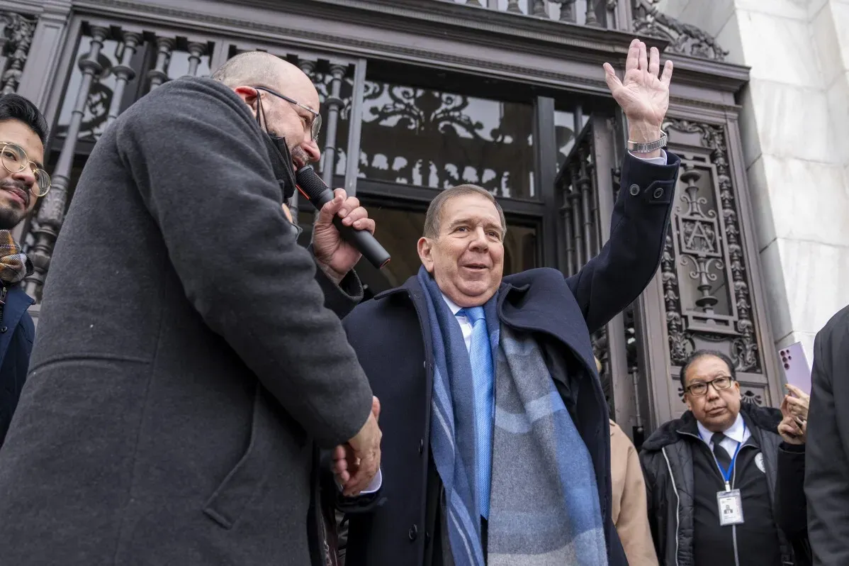 إدموندو غونزاليس يلوح بيده خلال حدث عام، محاطًا بداعمين، بينما يتحدث عن تحدياته كزعيم للمعارضة في فنزويلا.