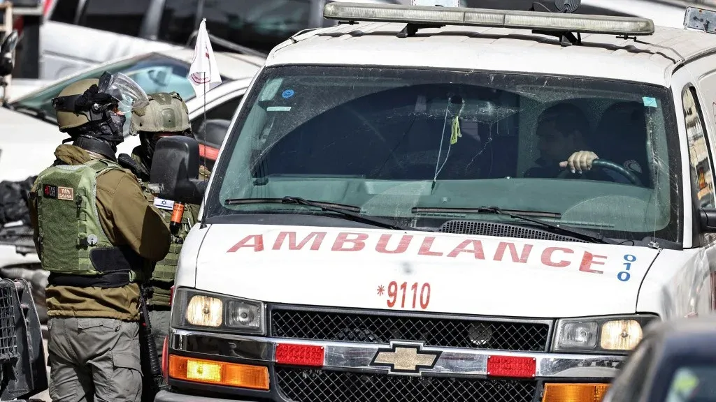 جنود إسرائيليون يفحصون سيارة إسعاف عند نقطة تفتيش في الضفة الغربية وسط تصاعد العنف وقيود التنقل التي تعيق الوصول للرعاية الصحية الفلسطينية.