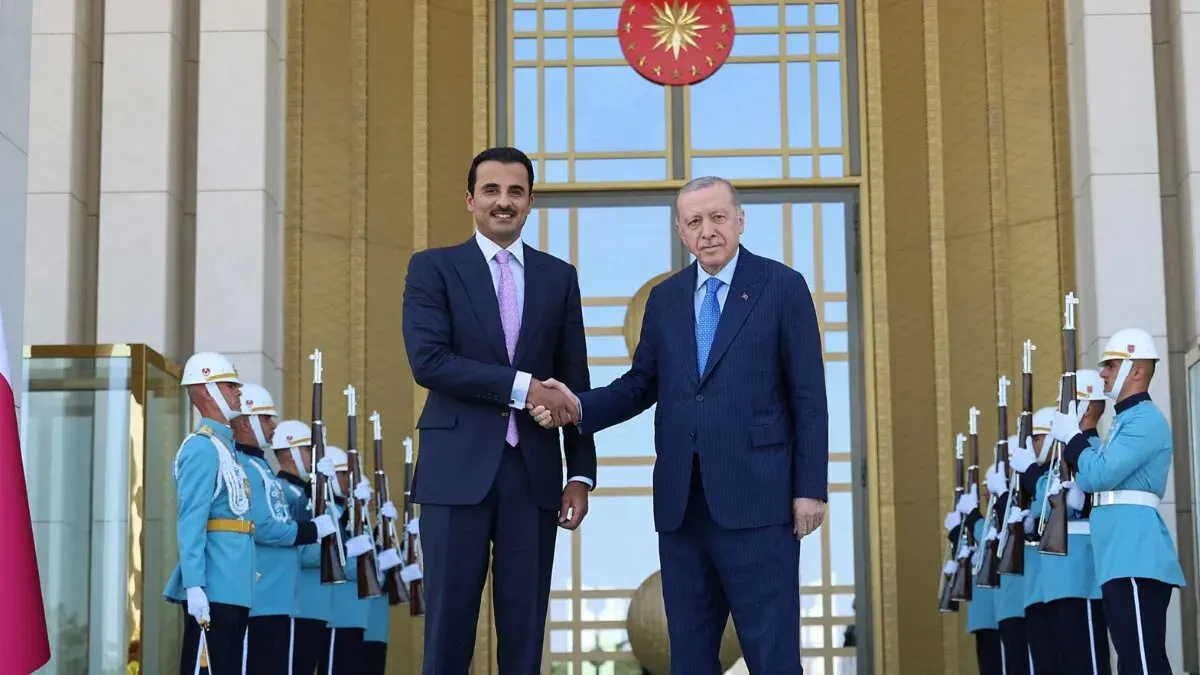 لقاء بين أمير قطر تميم بن حمد آل ثاني والرئيس التركي رجب طيب أردوغان، مع حرس الشرف في الخلفية، يعكس التعاون الإقليمي في إعادة إعمار سوريا.
