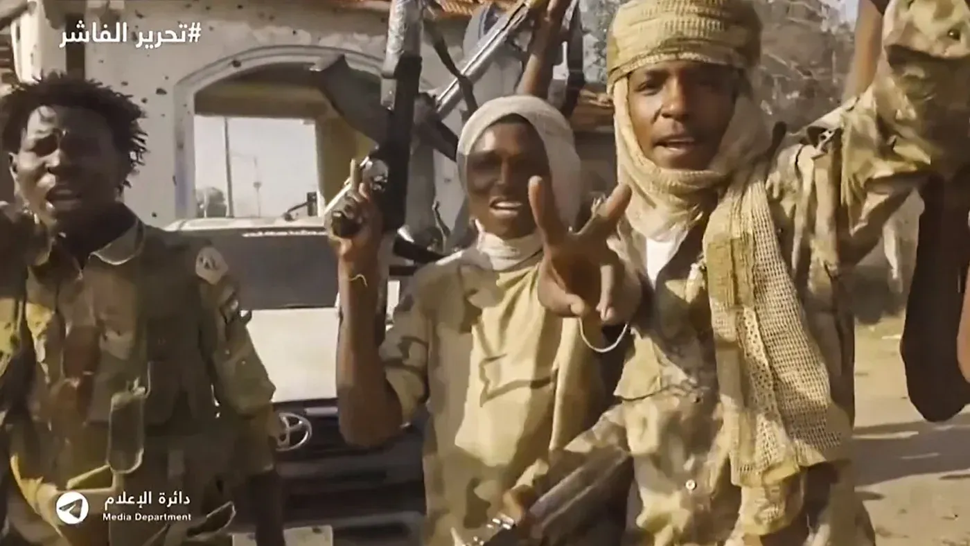 مقاتلون من قوات الدعم السريع في الفاشر، يحملون أسلحة ويظهرون علامات النصر، وسط أجواء من التوتر بعد السيطرة على المدينة.