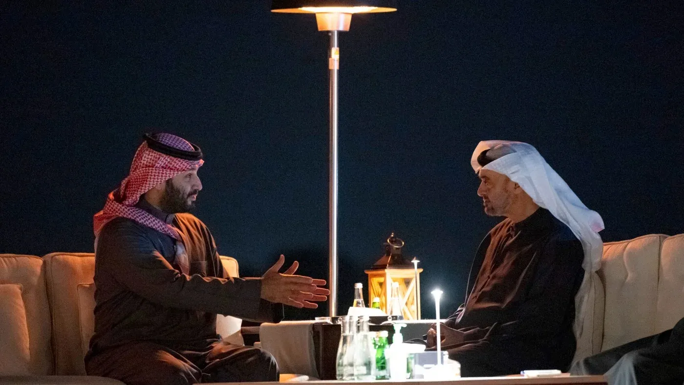 لقاء بين ولي العهد السعودي محمد بن سلمان ورئيس الإمارات محمد بن زايد، يتبادلان الحديث في أجواء هادئة، مع إضاءة خافتة.