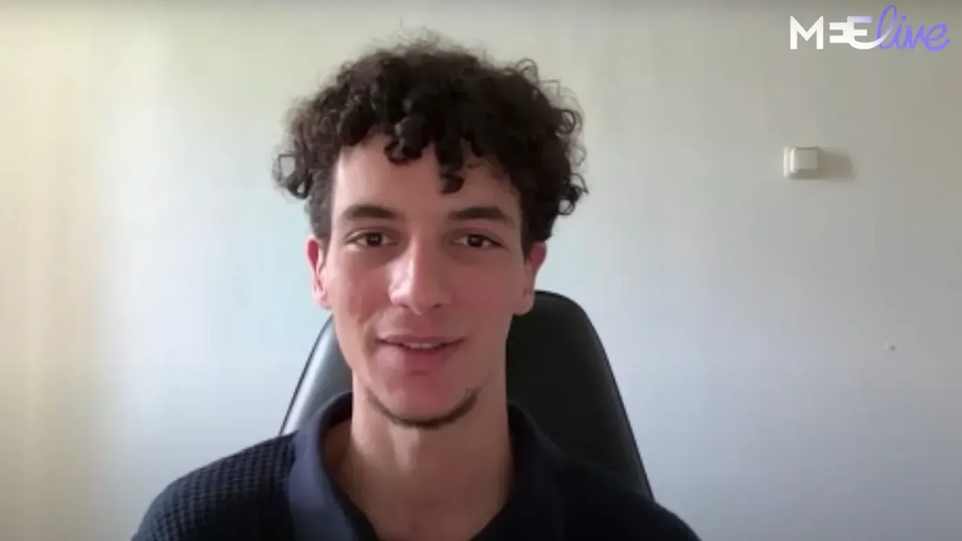ناشط مصري يتحدث في مقابلة، مع خلفية بسيطة، معبراً عن احتجاجه ضد تواطؤ مصر في الإبادة الجماعية في غزة.