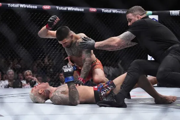 إيليا توبوريا يوجه ضربة قاضية قوية لتشارلز أوليفيرا في UFC 317، بينما يتدخل الحكم لإنهاء النزال بعد سقوط أوليفيرا.