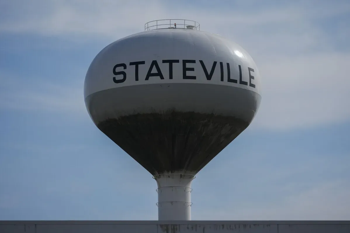 برج مياه مكتوب عليه "STATEVILLE" في سماء زرقاء، يرمز إلى إغلاق سجن ستايتفيل في إلينوي ونقل السجناء إلى مرافق أخرى.