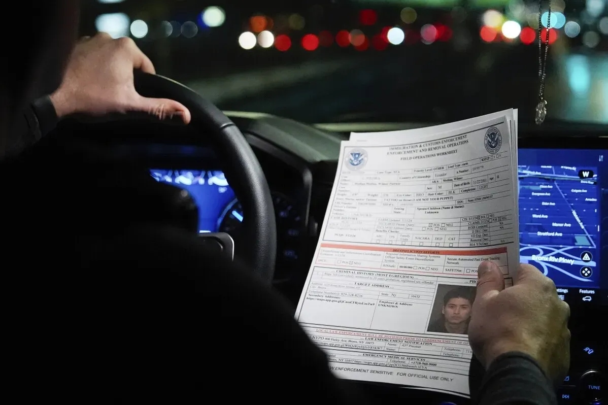 وثيقة رسمية تتعلق بإنفاذ قوانين الهجرة تُرفع من قبل شخص يقود السيارة، مع خلفية مضيئة تعكس أجواء التوتر في شيكاغو.