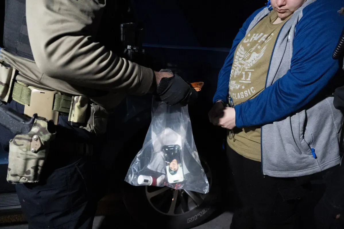 ضباط من إدارة الهجرة والجمارك يفتشون شخصًا خلال عملية اعتقال تستهدف مهاجرين غير قانونيين في ماريلاند.