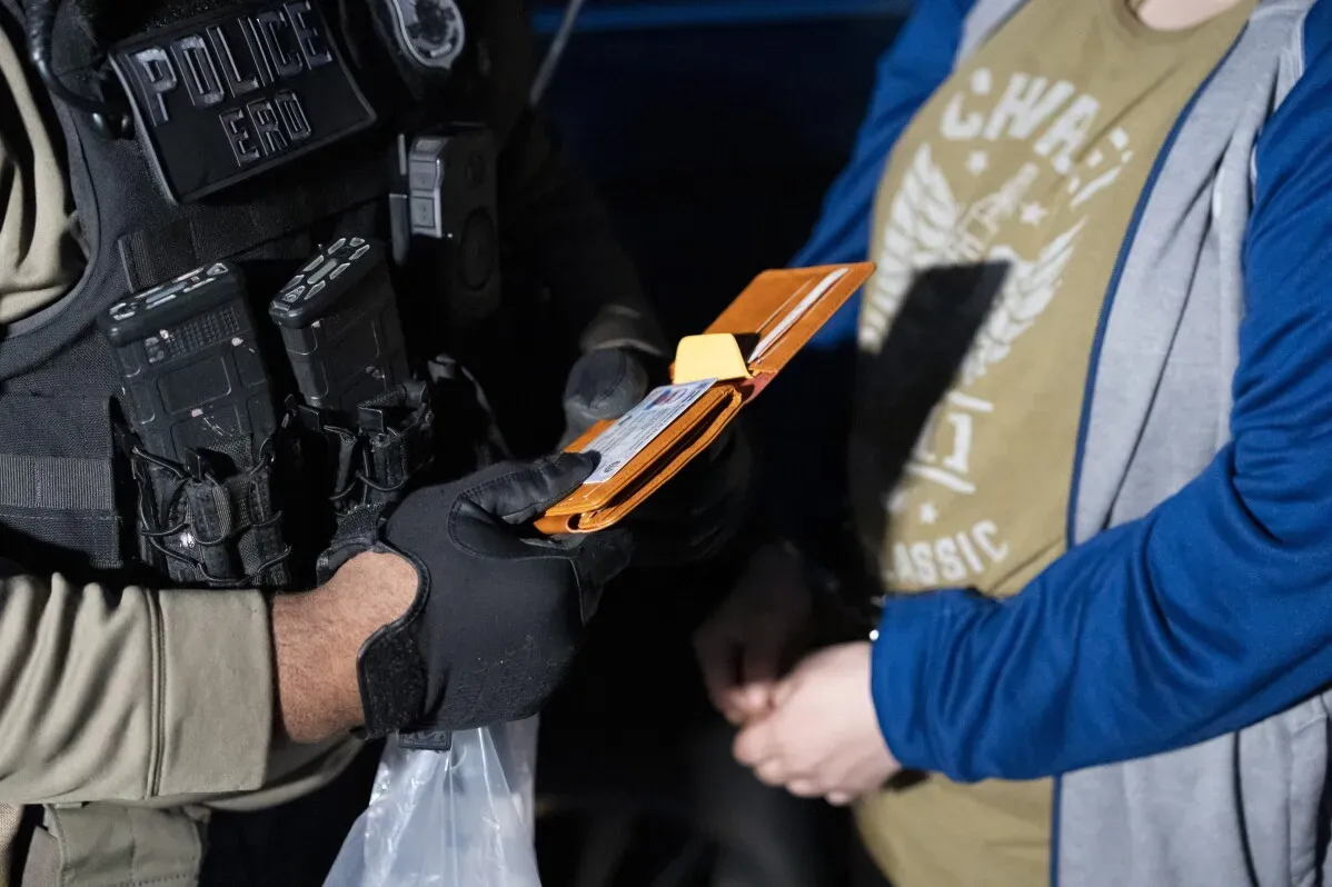 ضباط الهجرة والجمارك يتحققون من هوية شخص في سيارة، مع التركيز على إنفاذ القانون وتحديد المهاجرين غير الشرعيين في ماريلاند.