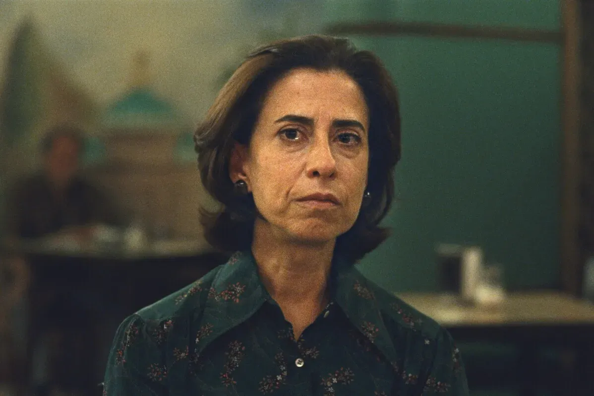 يونيس بايفا، الشخصية الرئيسية في فيلم \"Im still here\"، تنظر بجدية، تعكس قوة المقاومة في مواجهة القمع السياسي.