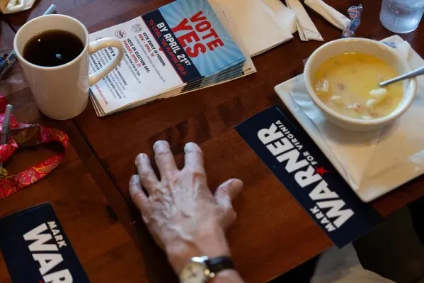 مائدة تحتوي على كوب قهوة، وعاء حساء، ومواد دعائية تدعو للتصويت بنعم في استفتاء إعادة تقسيم الدوائر الانتخابية في فيرجينيا.