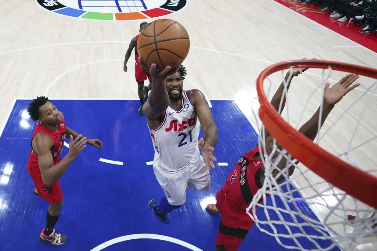 إمبييد يسجل نقطة خلال مباراة سابقة مع فريق 76ers، مع وجود لاعبين آخرين في الخلفية، مما يعكس تحدياته في الموسم بسبب الإصابات.