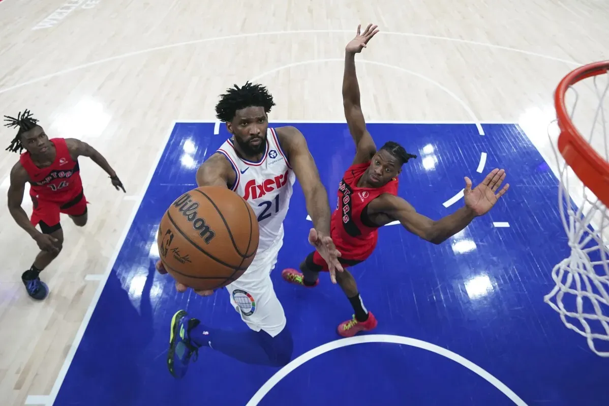 جويل إمبيد يسجل نقطة في مباراة لفريق 76ers، بينما يتصدى له لاعب من فريق الخصم. تعكس الصورة التوترات في موسم الفريق بسبب الإصابات.