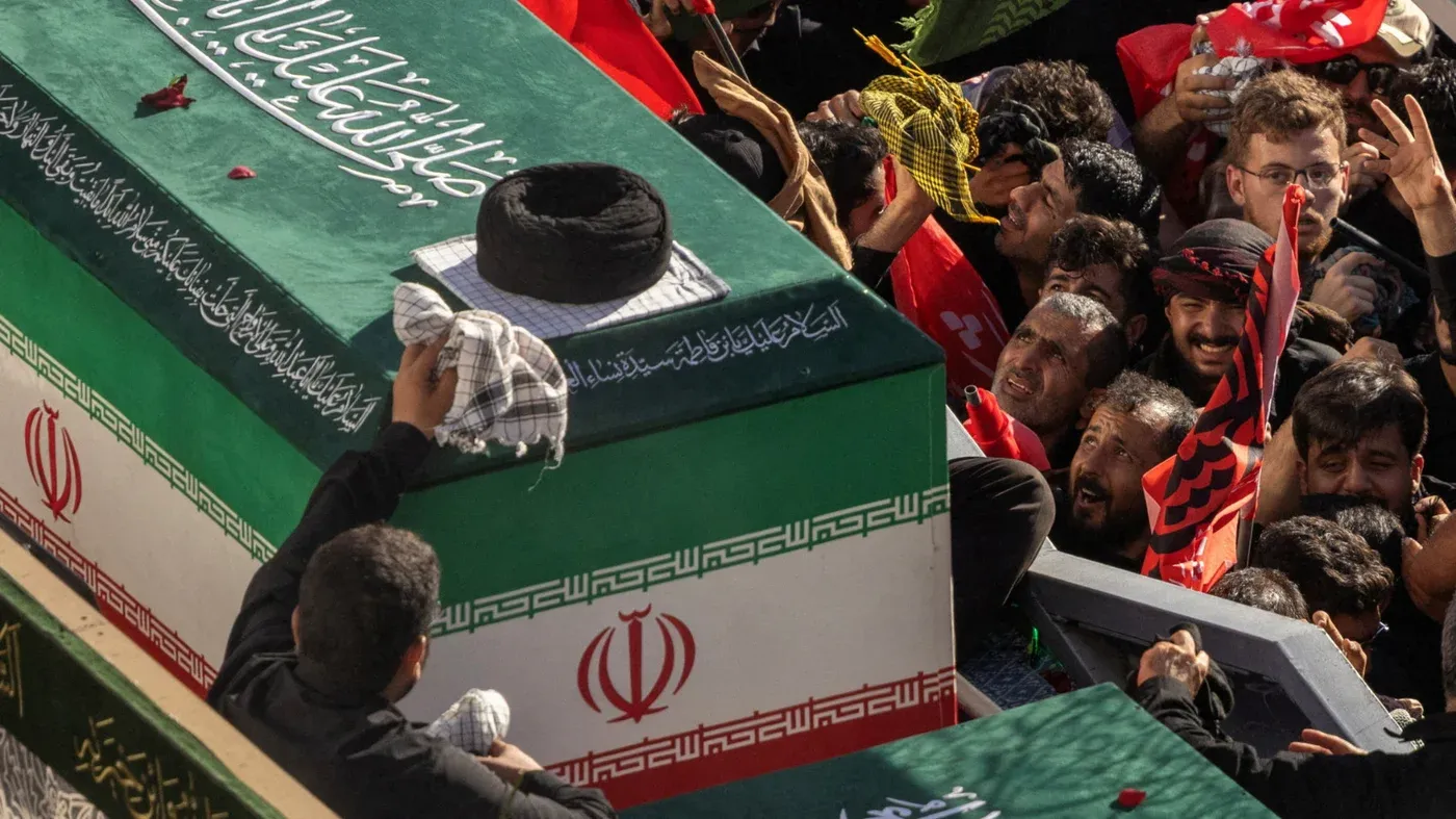 جنازة آية الله علي خامنئي في مشهد بإيران مع حضور حشود كبيرة ونعش مغطى بعلم إيران وأغطية دينية، تعبير عن التشييع الرسمي.
