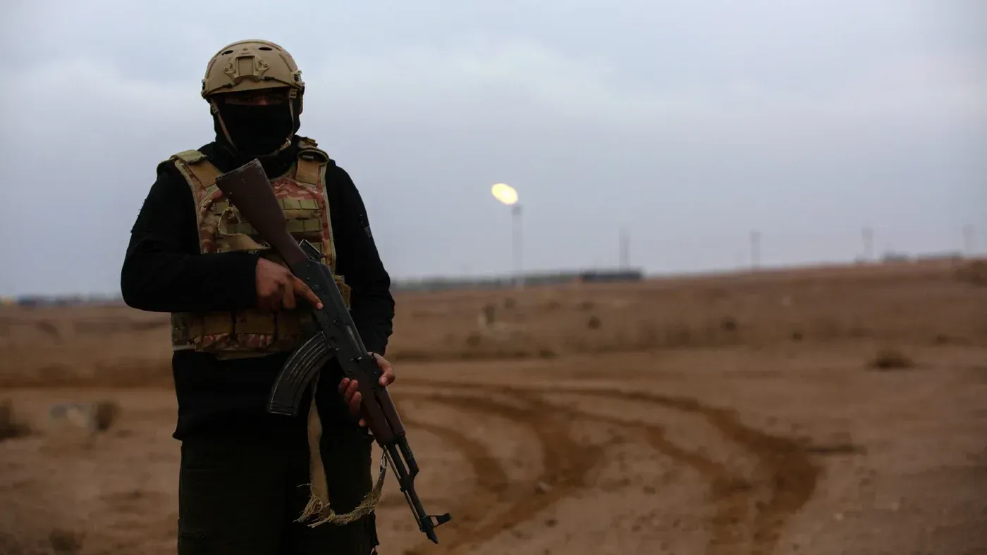 أبو عائشة، رئيس سابق للأمن المصرفي، يقوم بدورية في حقل العمر النفطي في شمال شرق سوريا، محاطًا بمشهد دمار وخراب.