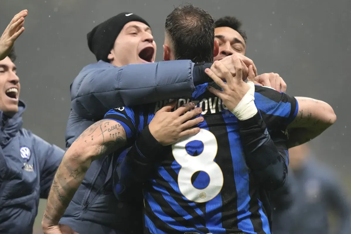 لاعبو إنتر ميلان يحتفلون بفوزهم في مباراة كأس إيطاليا، مع التركيز على مشاعر الفرح والحماس بين الفريق.