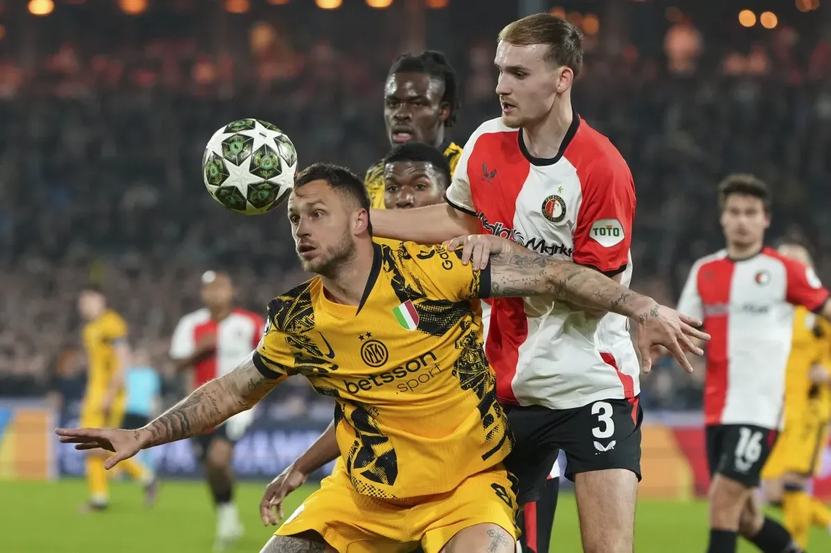 لاعبو إنتر ميلان يتنافسون مع لاعبي فينورد خلال مباراة دوري أبطال أوروبا، حيث يظهر التوتر والمنافسة الشديدة في الملعب.
