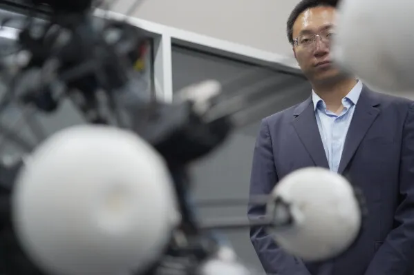 روبوت Argus الكروي مع 20 ساقاً تلسكوبية، يظهر خلفه البروفيسور Boyuan Chen في مختبر جامعة Duke، يمثل مبدأ "التناسق الديناميكي".