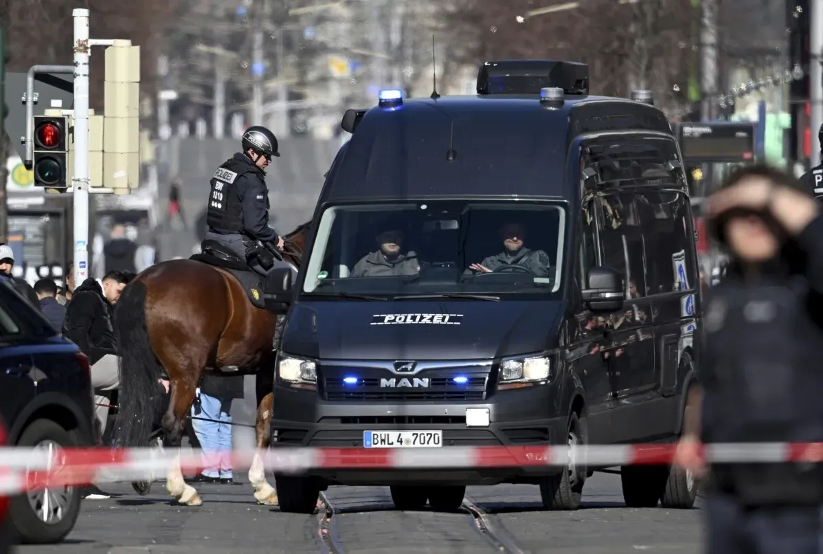 سيارة شرطة كبيرة مع ضابط على ظهر حصان في موقع حادث دهس بحشد في مانهايم، ألمانيا، حيث قُتل شخصان وأصيب آخرون.