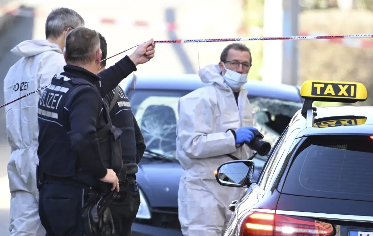 تحقيقات الشرطة جارية في موقع حادث صدم سيارة بحشد في مانهايم، مع وجود ضباط يرتدون زيًا خاصًا واهتمام بالسيارة المتضررة.