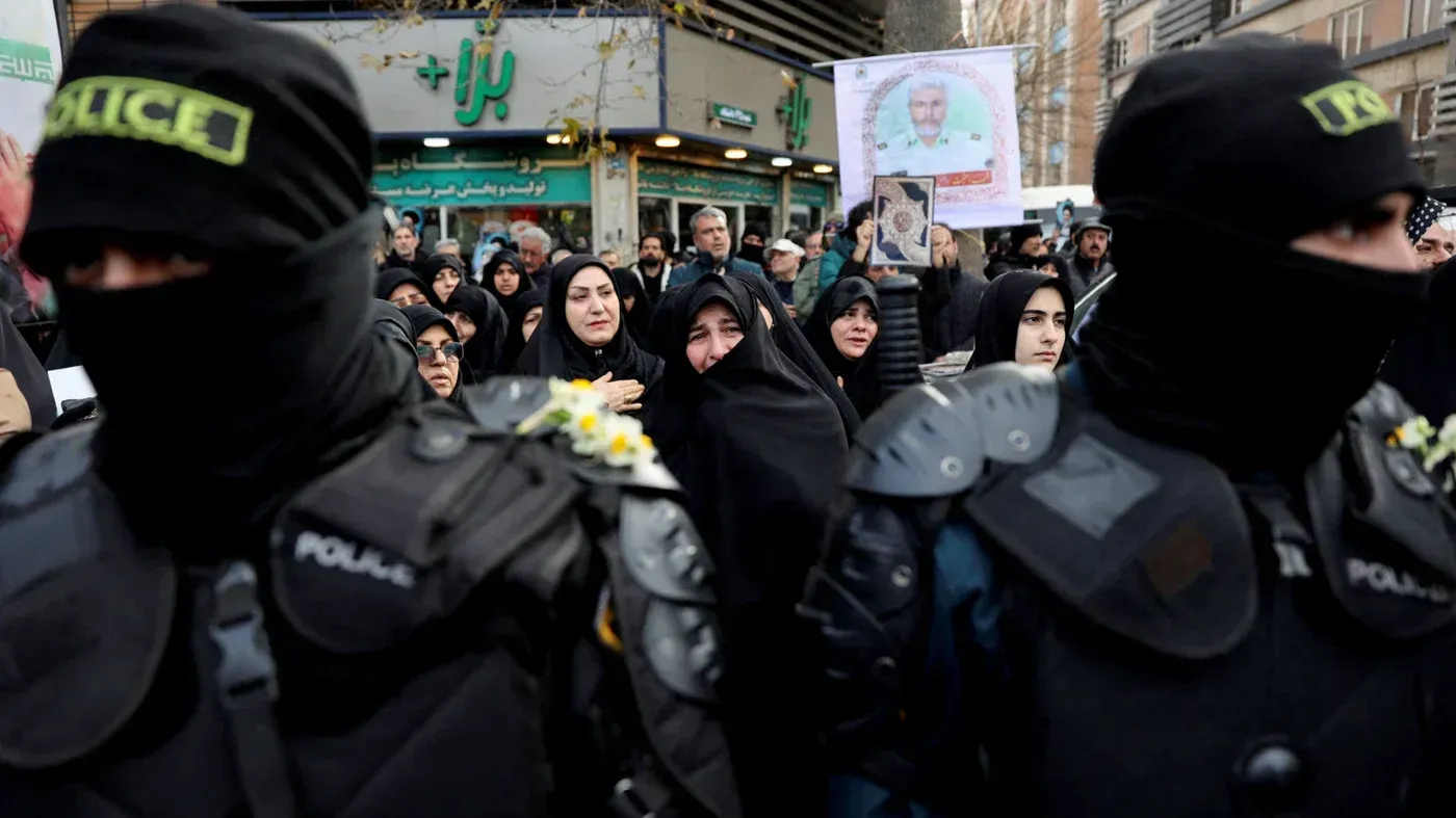 محتجون في إيران يتجمعون خلال مظاهرة، مع وجود قوات الأمن في المقدمة، وسط تدهور الأوضاع الاقتصادية واحتجاجات ضد الحكومة.