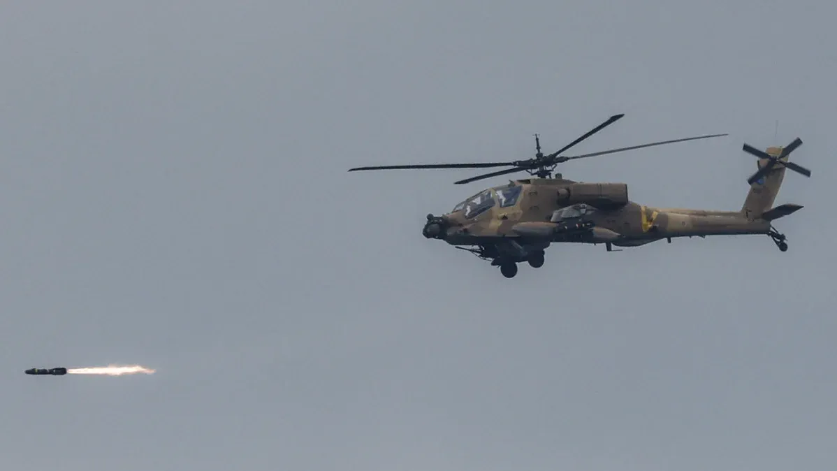 مروحية هجومية من طراز Apache تطلق صاروخاً، تعكس التوترات العسكرية بين الولايات المتحدة وإيران في مضيق هرمز.