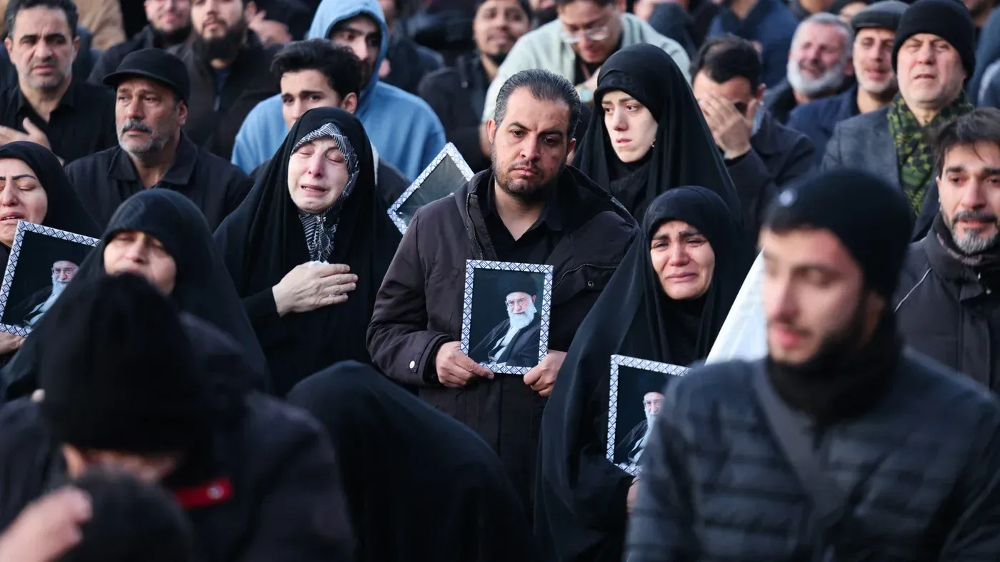 تجمع حشود من المعزين في طهران، يرتدون الملابس السوداء ويحملون صور علي خامنئي، معبرين عن حزنهم واحتجاجهم على وفاته.