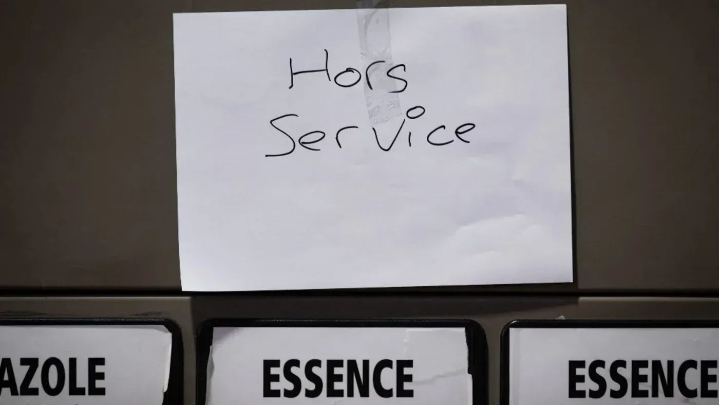 لافتة مكتوبة بخط اليد تشير إلى أن الخدمة متوقفة، مع وجود خيارات الوقود مثل الديزل والبنزين في الأسفل.