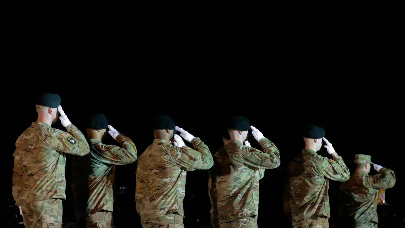 جنود أمريكيون يؤدون التحية العسكرية في قاعدة عسكرية، في سياق التصعيد العسكري مع إيران. الهجوم الأخير أدى لإصابات عديدة.