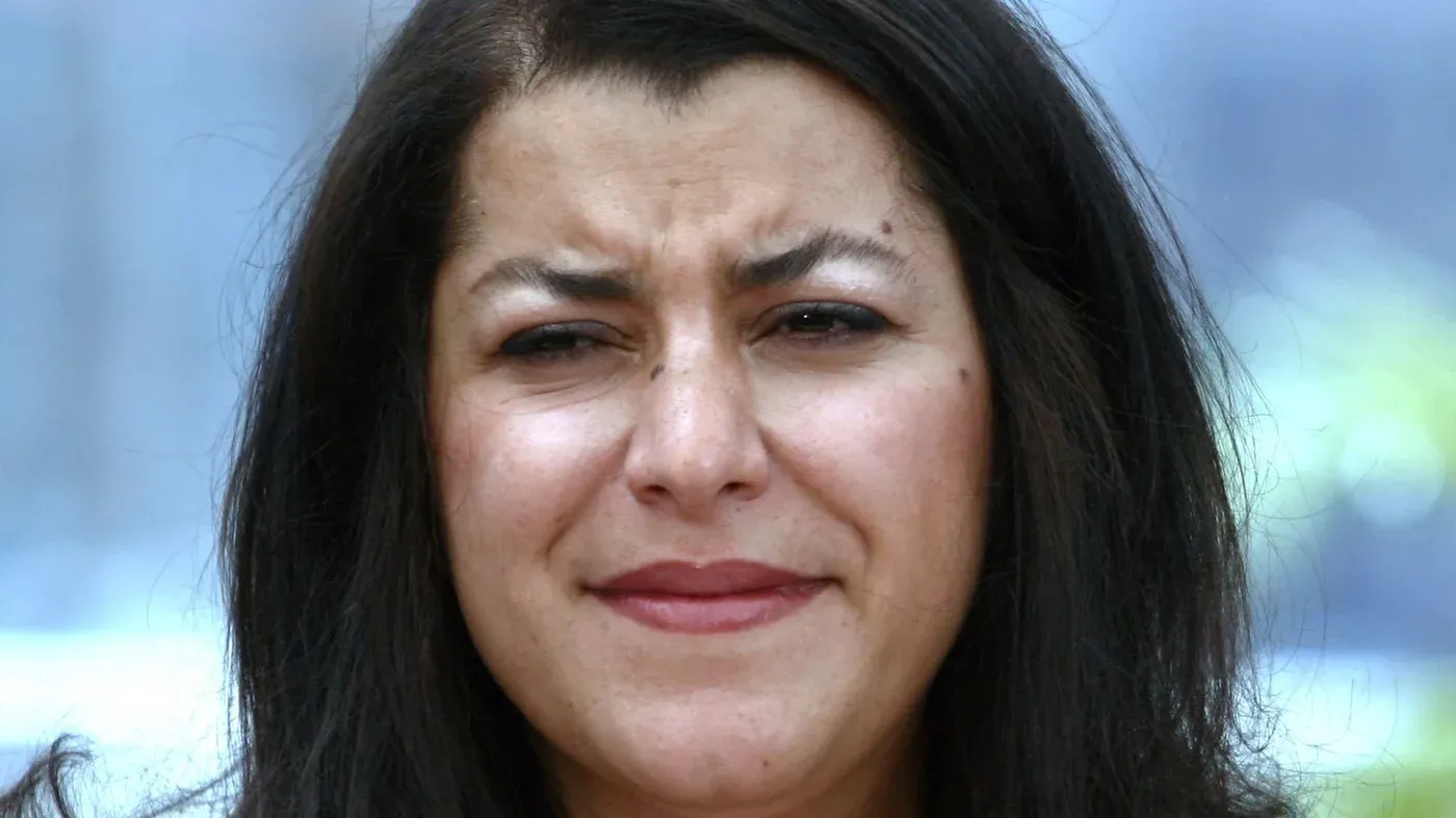 تعبّر الصورة عن مشاعر الحزن والأسى، حيث تظهر Marjane Satrapi، الفنانة والمخرجة الإيرانية-الفرنسية، في لحظة تأمل بعد وفاتها.