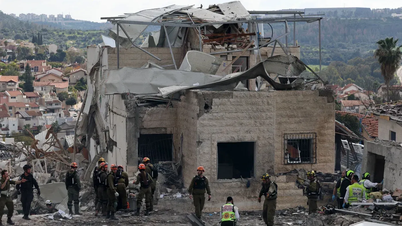 موقع الهجوم الصاروخي الإيراني في بيت شيمش، يظهر دمارًا كبيرًا في المبنى مع وجود فرق الإنقاذ في الموقع.