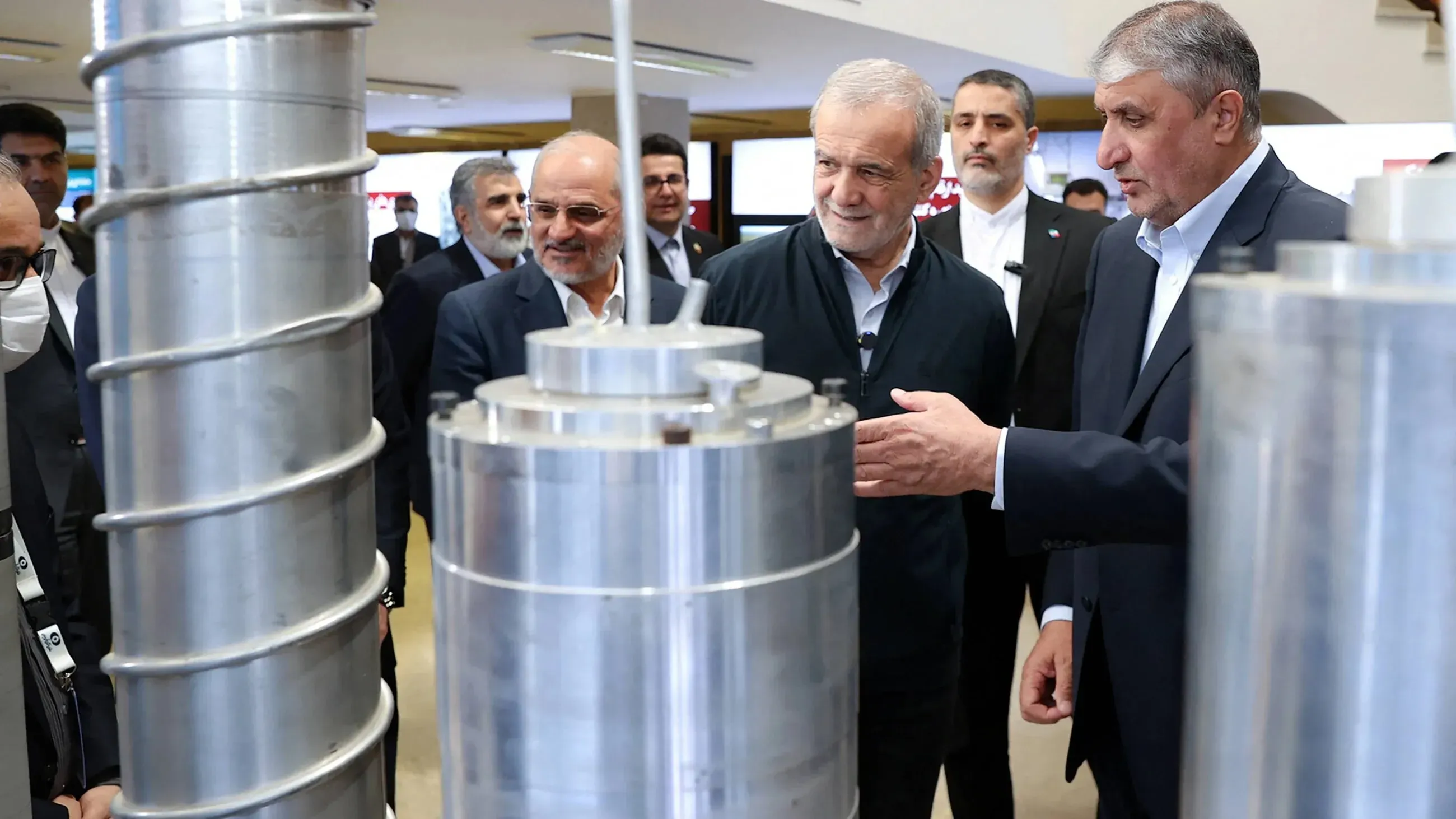 إيرانيون يتفقدون معدات نووية خلال زيارة لموقع مفاعل، مما يعكس استعداد إيران للتعاون مع الولايات المتحدة في مشاريع الطاقة النووية.